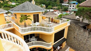 A multi-level building with a pool, outdoor seating, and a staircase. - Mermaid Resort Puerto Galera (Puerto Galera)