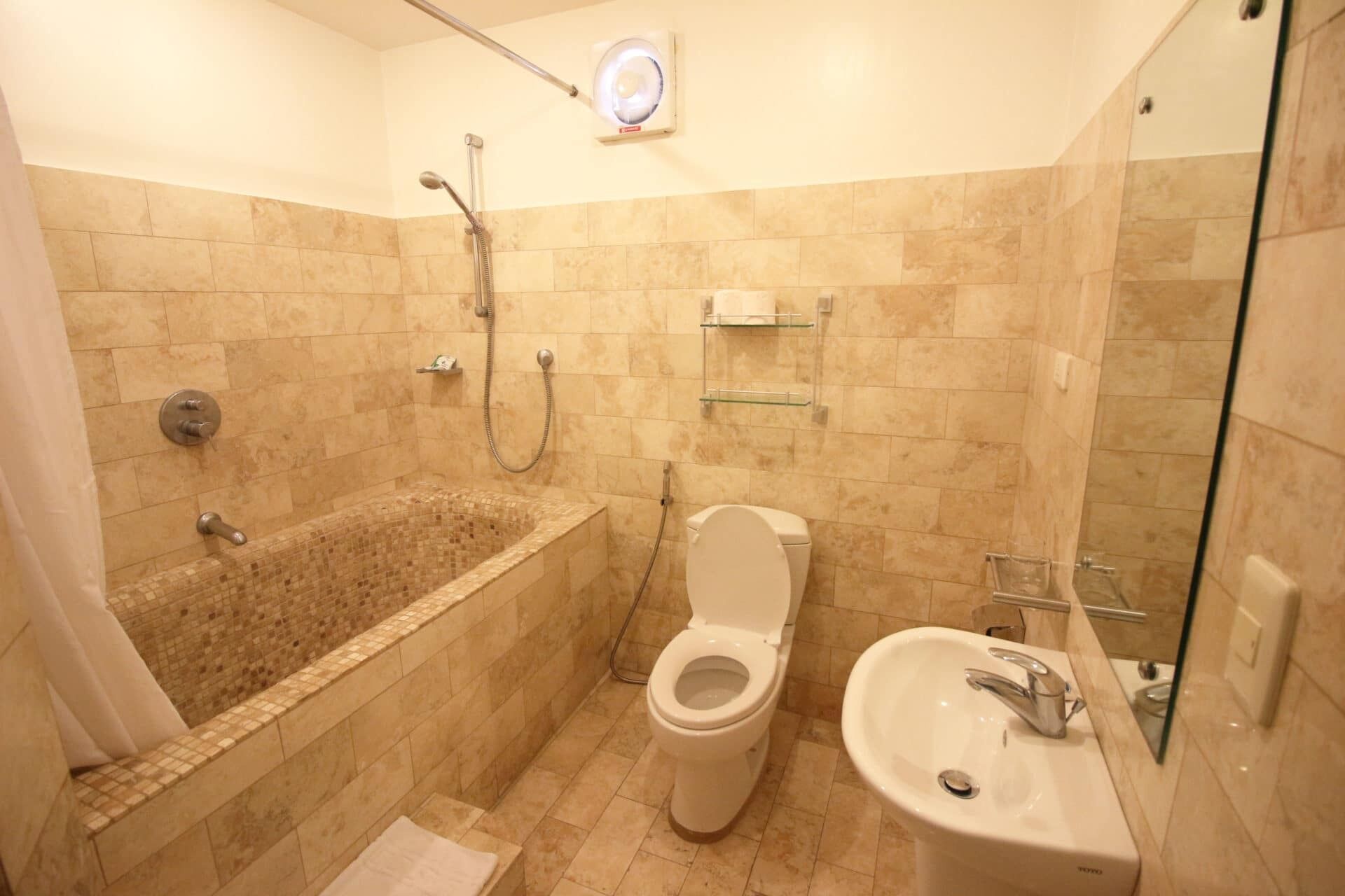 A bathroom with a bathtub, toilet, and sink.