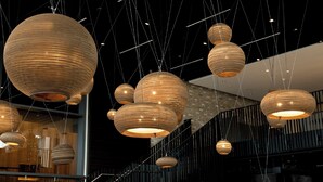 A modern interior with multiple spherical pendant lights hanging from the ceiling. - Motel One München-Campus (Munich)