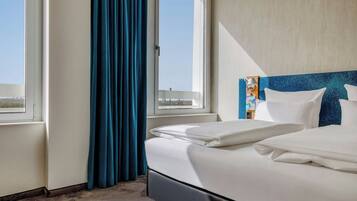 Une chambre d’hôtel avec un lit, une fenêtre et une vue sur la ville.