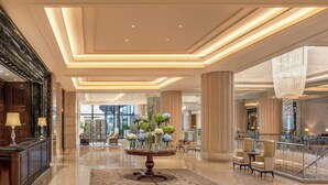 A spacious lobby with a central round table, elegant chairs, and a chandelier. - Waldorf Astoria Shanghai on the Bund (Shanghai)