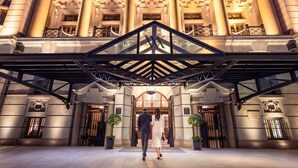 A grand entrance with a central archway, flanked by columns and potted plants. - Waldorf Astoria Shanghai on the Bund (Shanghai)