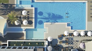 An aerial view of a hotel pool area with multiple sun loungers, umbrellas, and a clear blue pool. - ROBINSON QUINTA DA RIA - All Inclusive (Vila Real Santo Antonio)