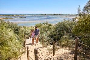 A wooden boardwalk leading to a beach with clear skies. - ROBINSON QUINTA DA RIA - All Inclusive (Vila Real Santo Antonio)
