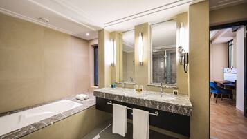A modern bathroom with a large bathtub, a double sink vanity, and a large mirror.