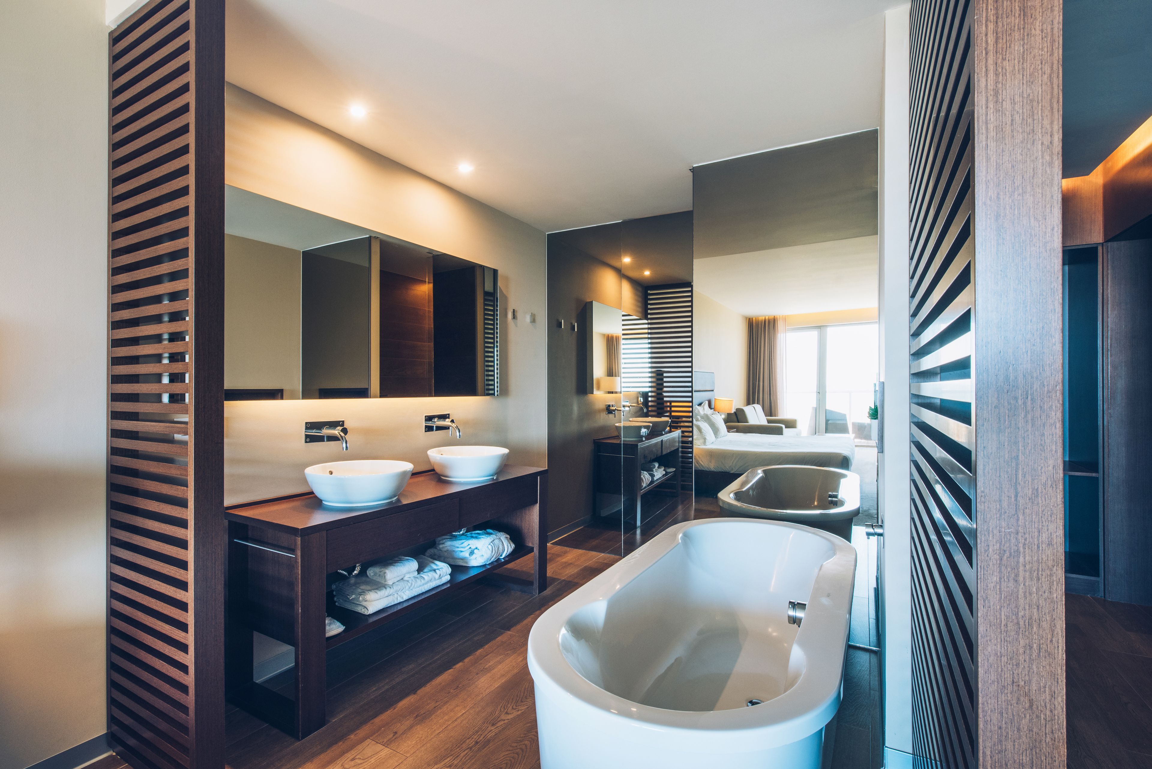 A modern bathroom with a freestanding bathtub, a double sink vanity, and a large mirror.