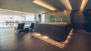 A modern hotel lobby with a reception desk, seating area, and a view of the outdoor space. - Iberostar Selection Lagos Algarve (Lagos)