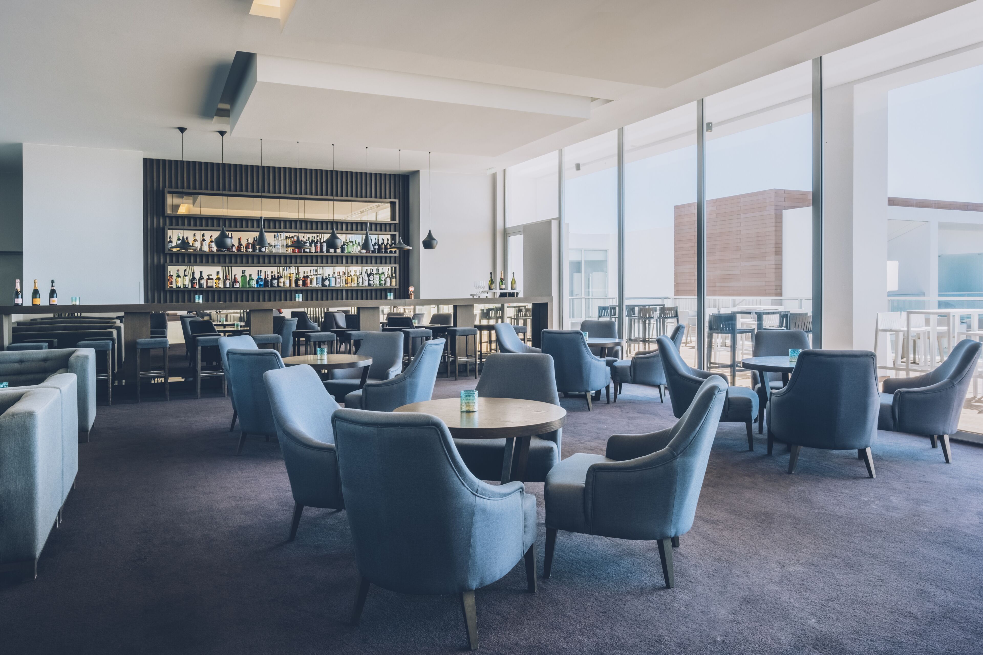 A modern bar area with seating and a large window.