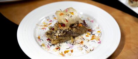 A dessert on a white plate with colorful toppings and a decorative element on top.