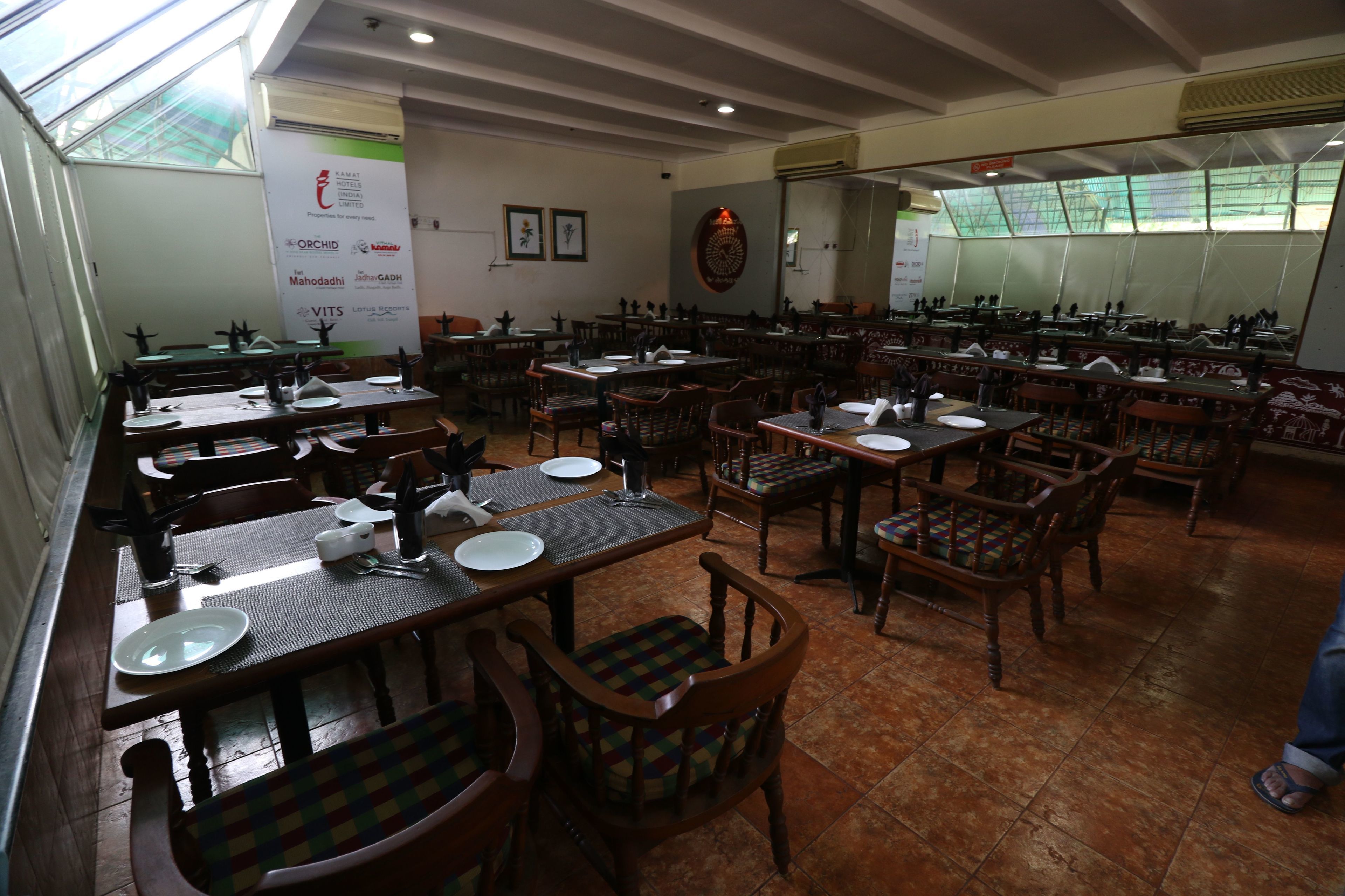 A restaurant with multiple dining tables and chairs, arranged in a spacious layout.