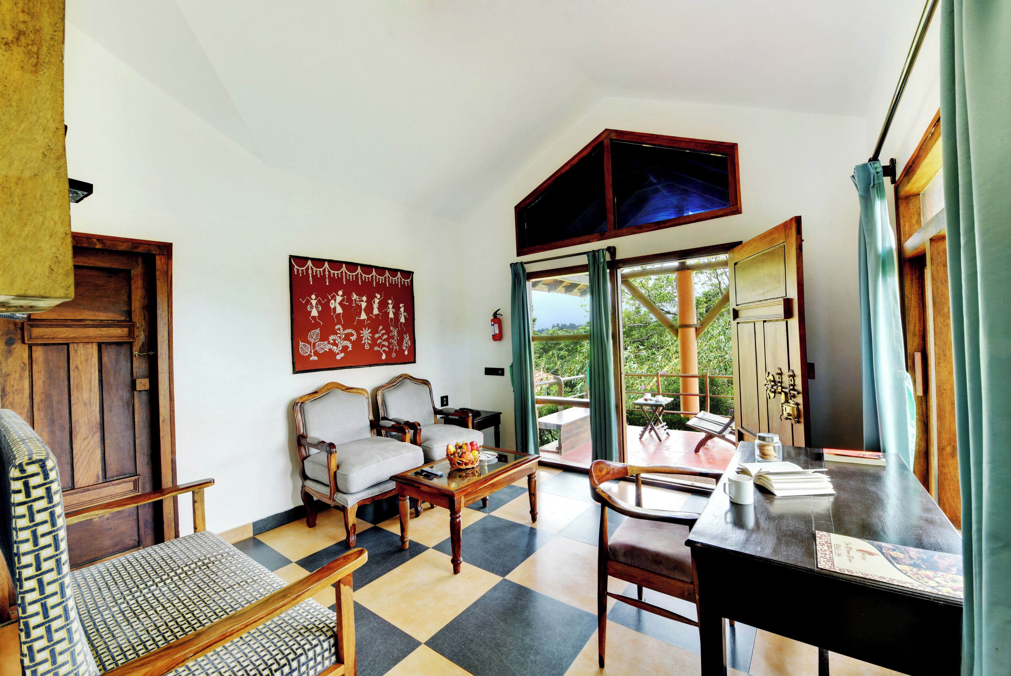 A room with a checkered floor, a sofa, a dining table with chairs, a painting on the wall, and a view through a glass door.