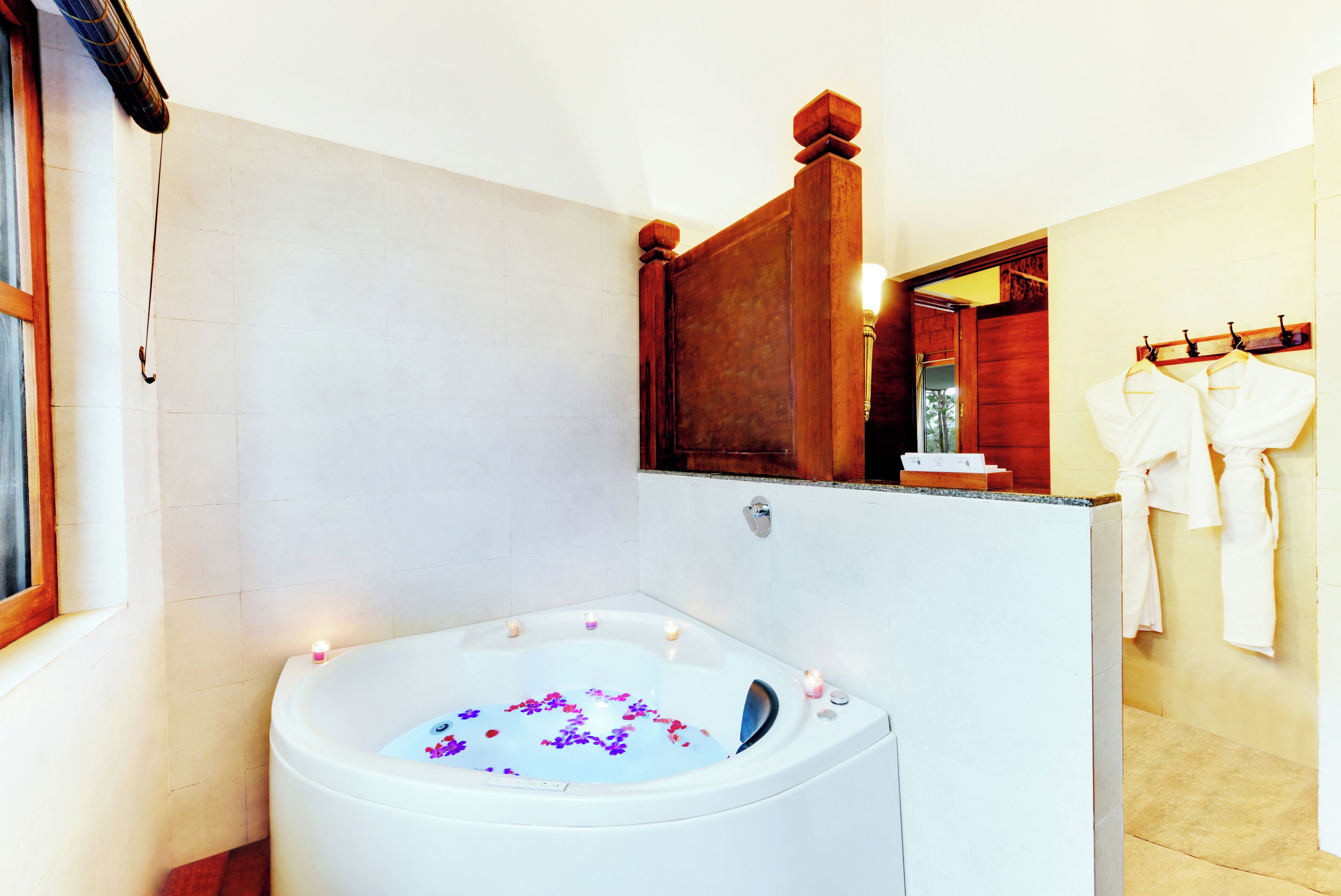 A modern bathroom with a freestanding bathtub, a wooden vanity, and a mirror above the sink.