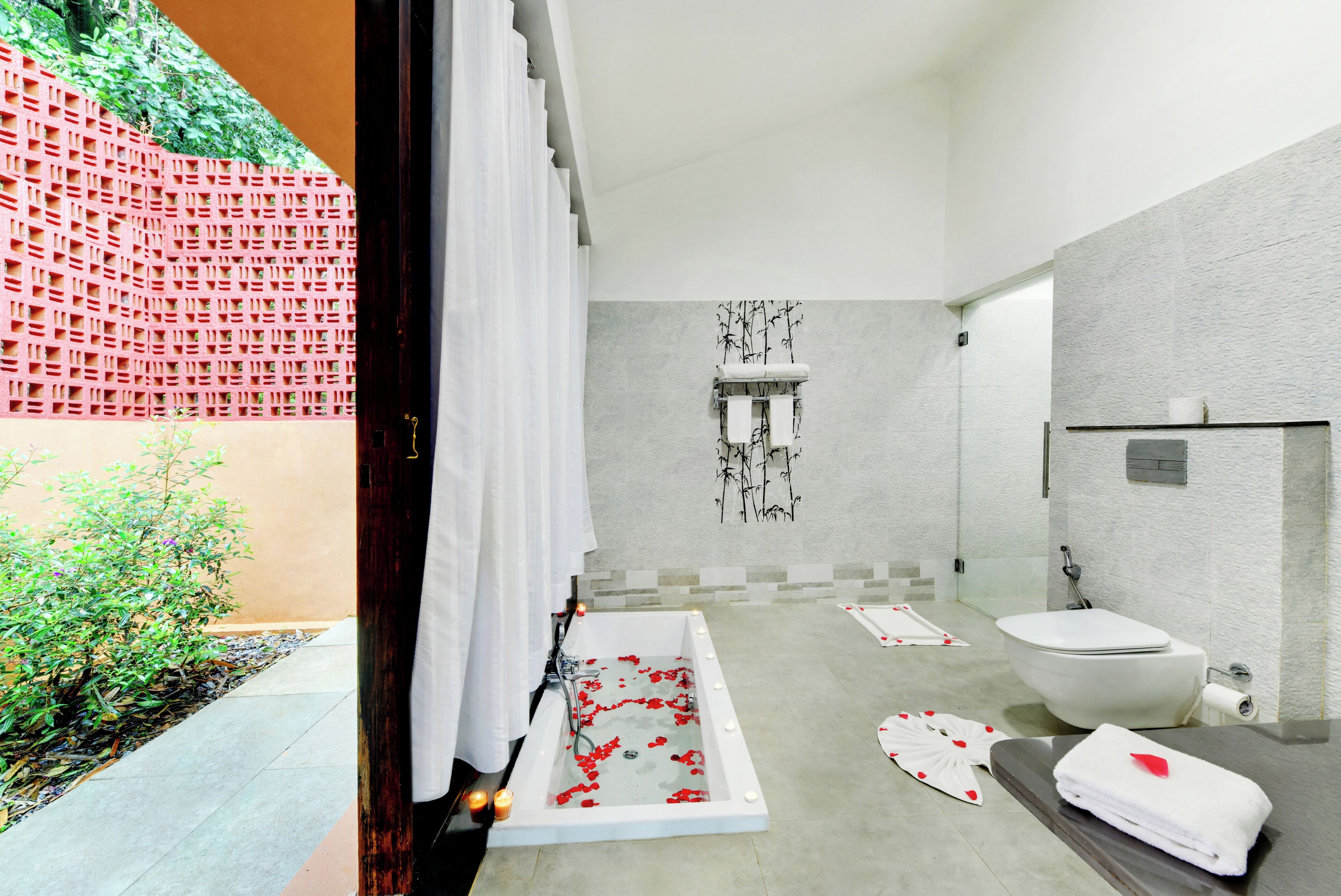 A modern bathroom with a bathtub, toilet, and shower area.