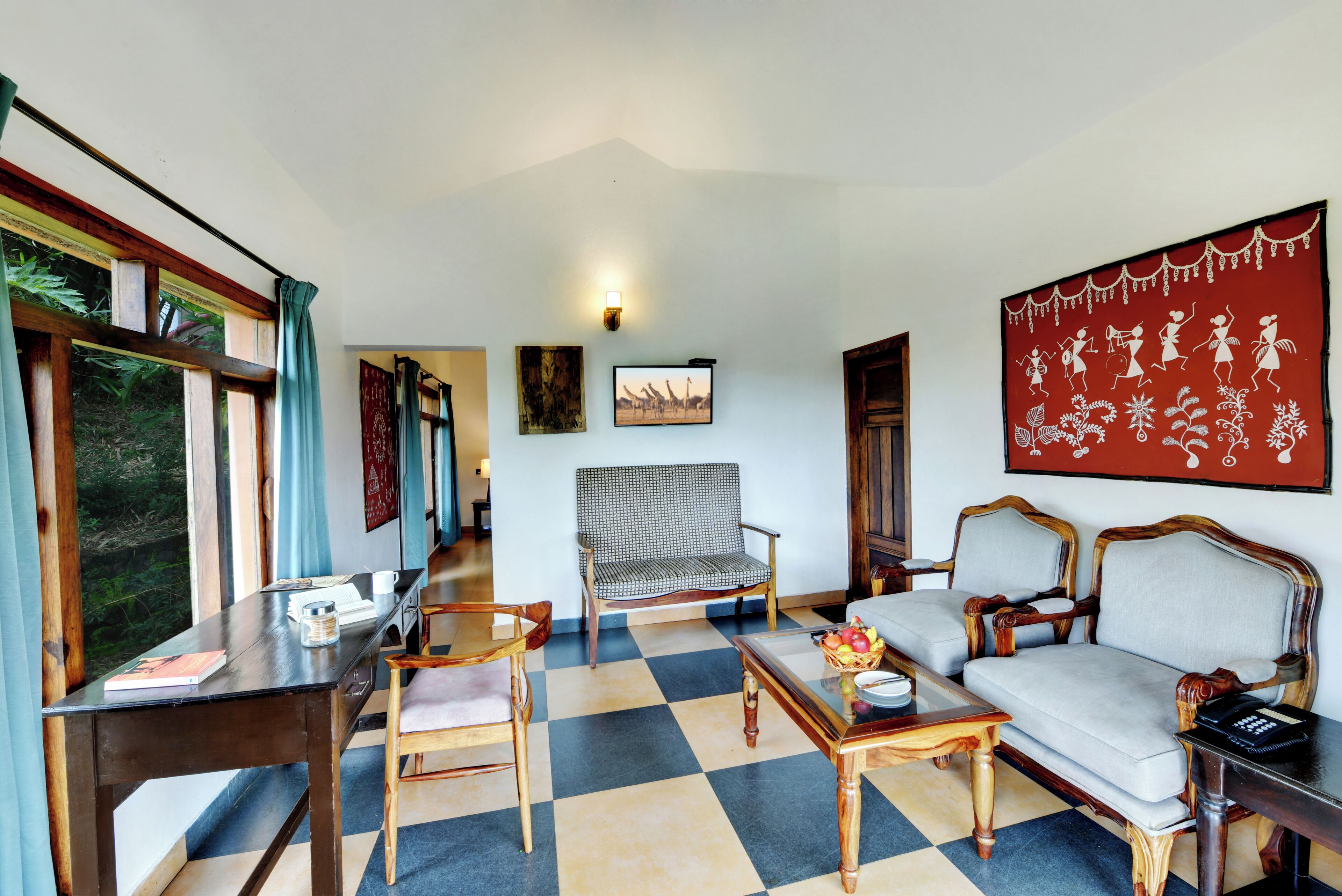 A room with a checkered floor, wooden furniture, a sofa, a chair, a table, and artwork on the walls.
