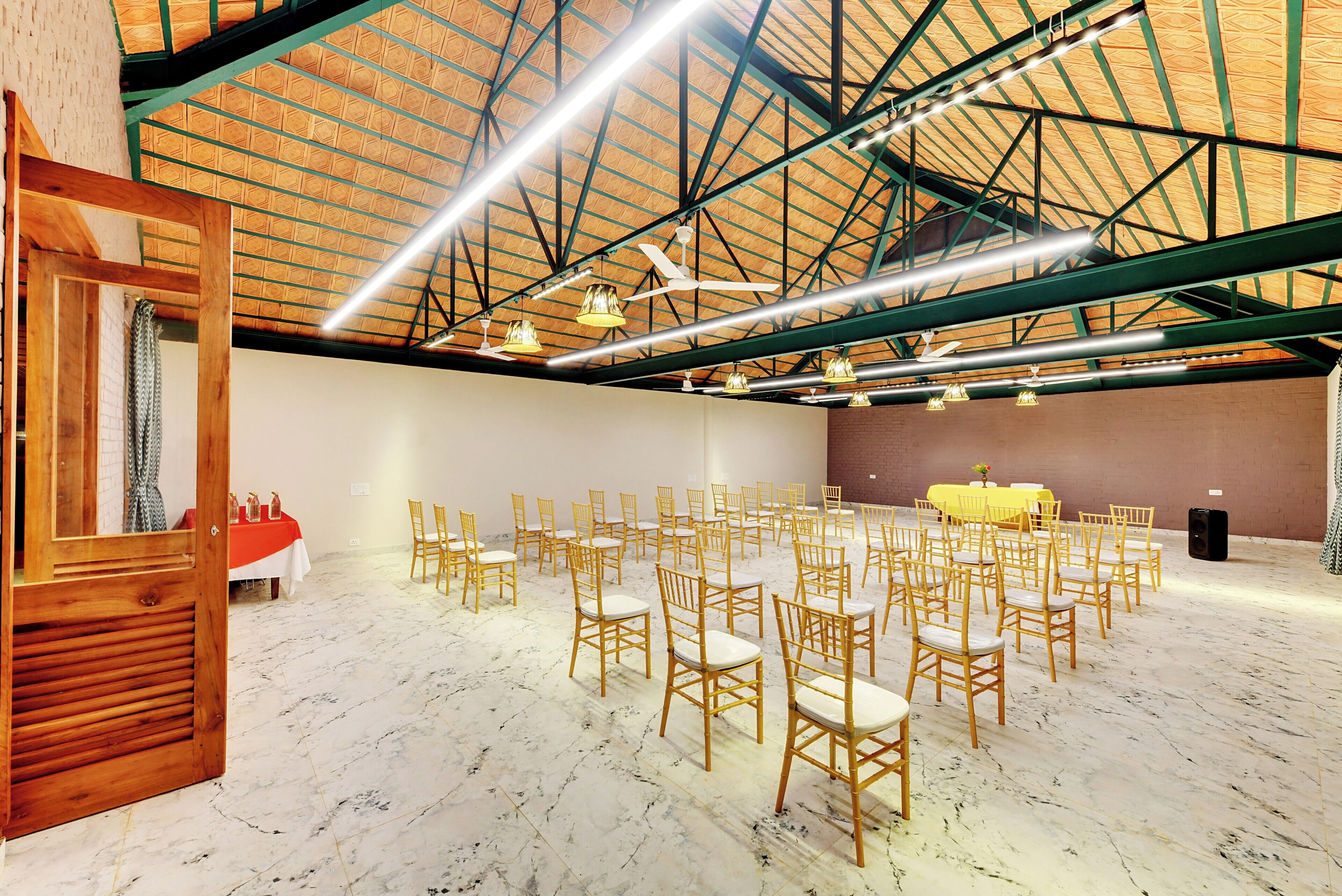 Ein geräumiger Saal mit hoher Decke, bestuhlter Bestuhlung und einer Bühne.