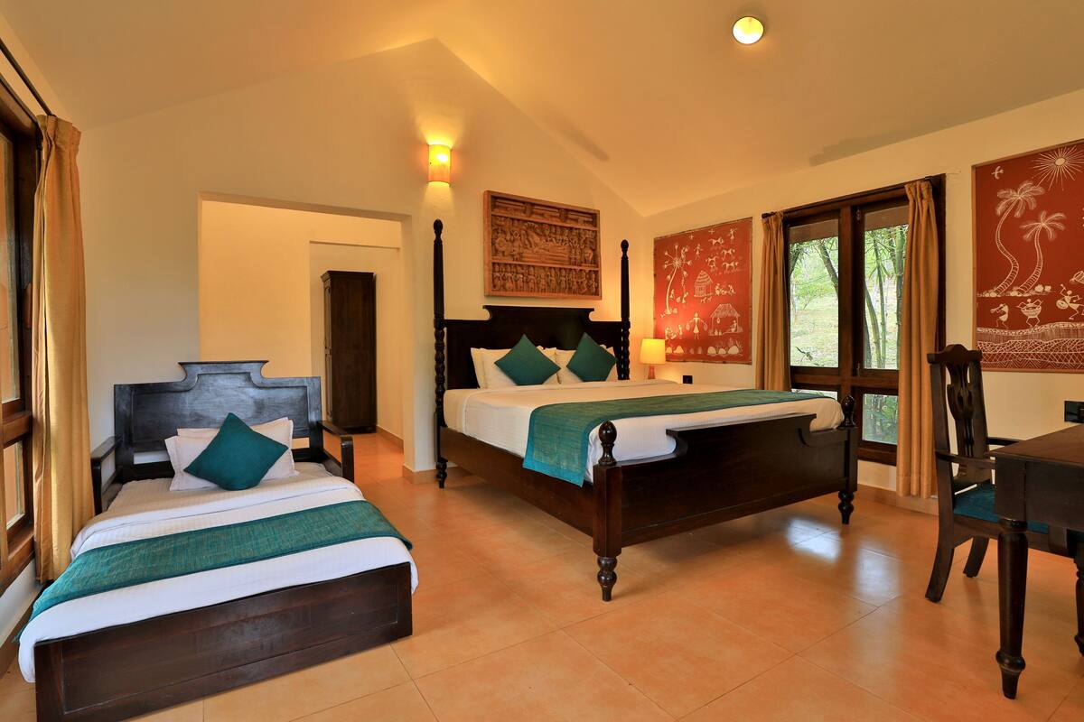 A room with two wooden beds, a desk, and a chair.