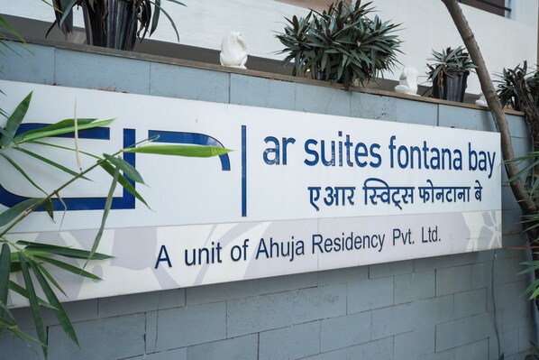 A sign for 'A unit of Ahuja Residency Pvt. Ltd.' with a logo and text in two languages. - AR Suites Fontana Bay (Pune)