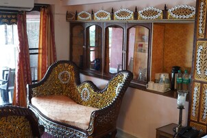 Une pièce de style traditionnel, meublée avec goût, comprenant un grand miroir et une petite table sur laquelle sont disposés divers objets.
