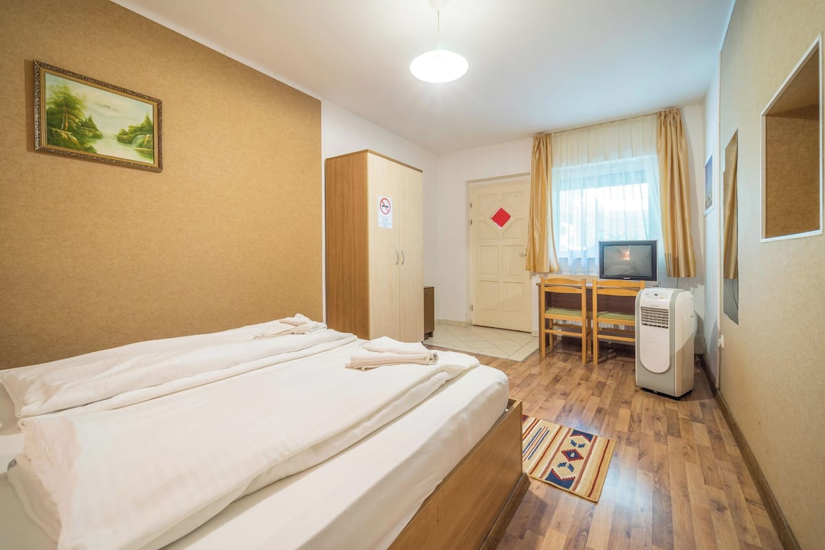 Ein Hotelzimmer mit Bett, Schreibtisch, Fernseher und Heizung.