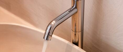 A modern bathroom sink with a chrome faucet and a beige basin.