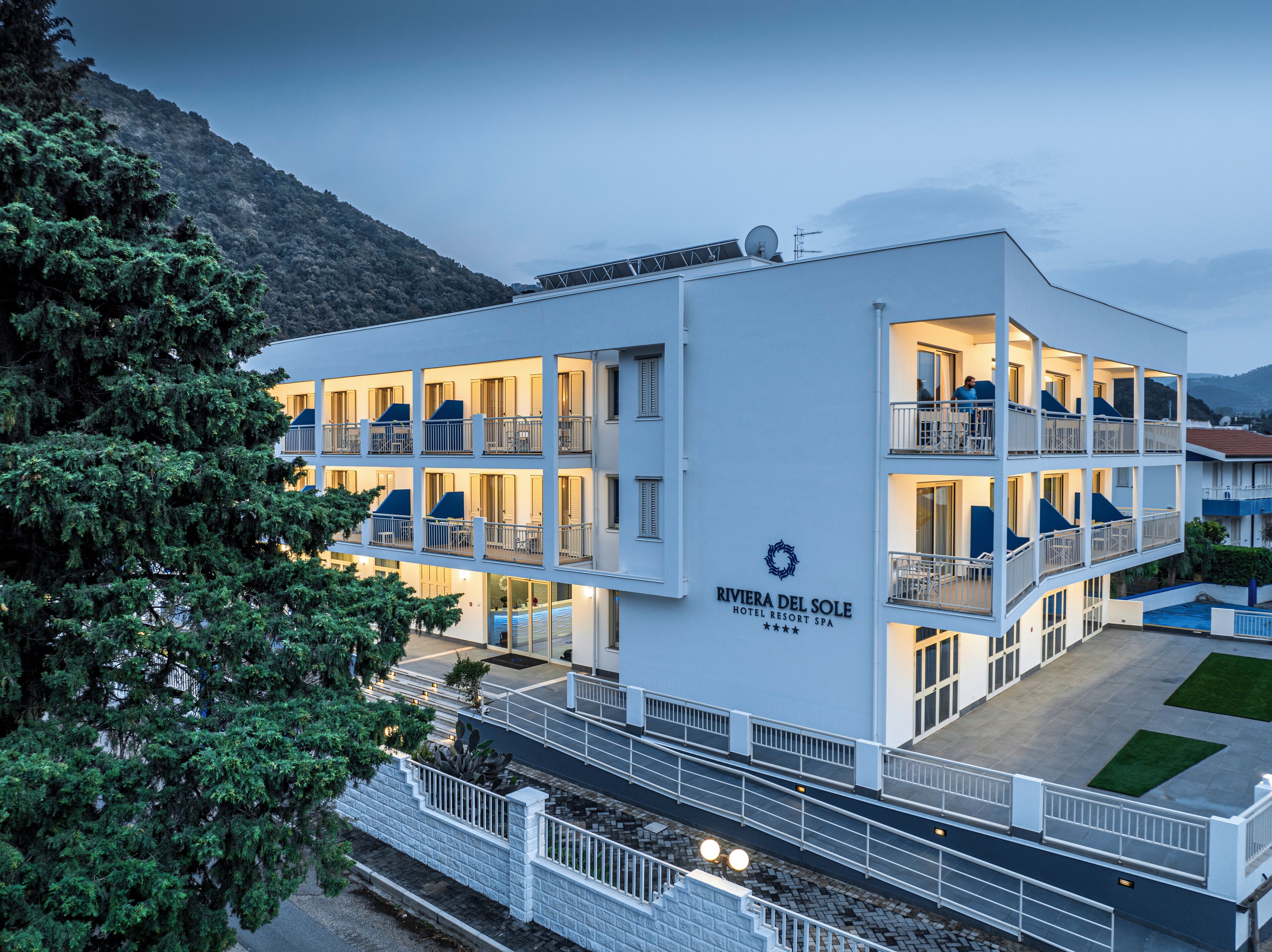 Um hotel de vários andares com varandas e uma placa com a inscrição 'Riviera del Sole Hotel Resort Spa'.