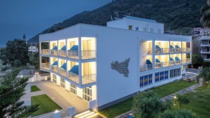 A multi-story hotel with balconies and a landscaped garden. - Riviera del Sole (Piraino)