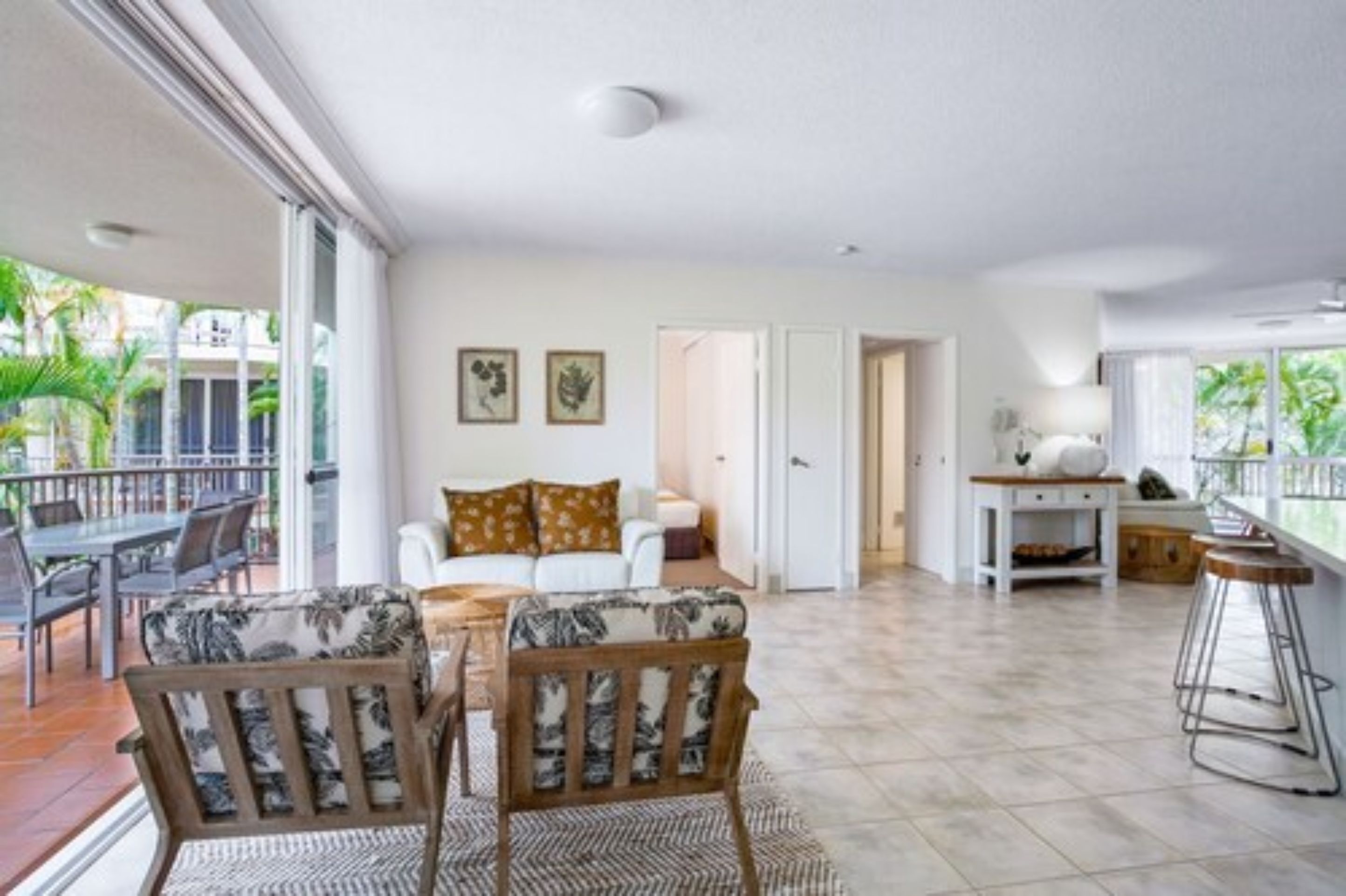 A spacious living area with a balcony, a dining table, and a sofa.