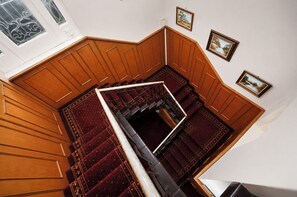 A wooden staircase with a handrail, carpeted steps, and framed pictures on the walls.