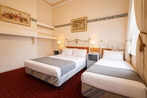 A hotel room with two beds, a red carpet, a white headboard, and a painting on the wall. - Georgian Court Inn (East Melbourne)
