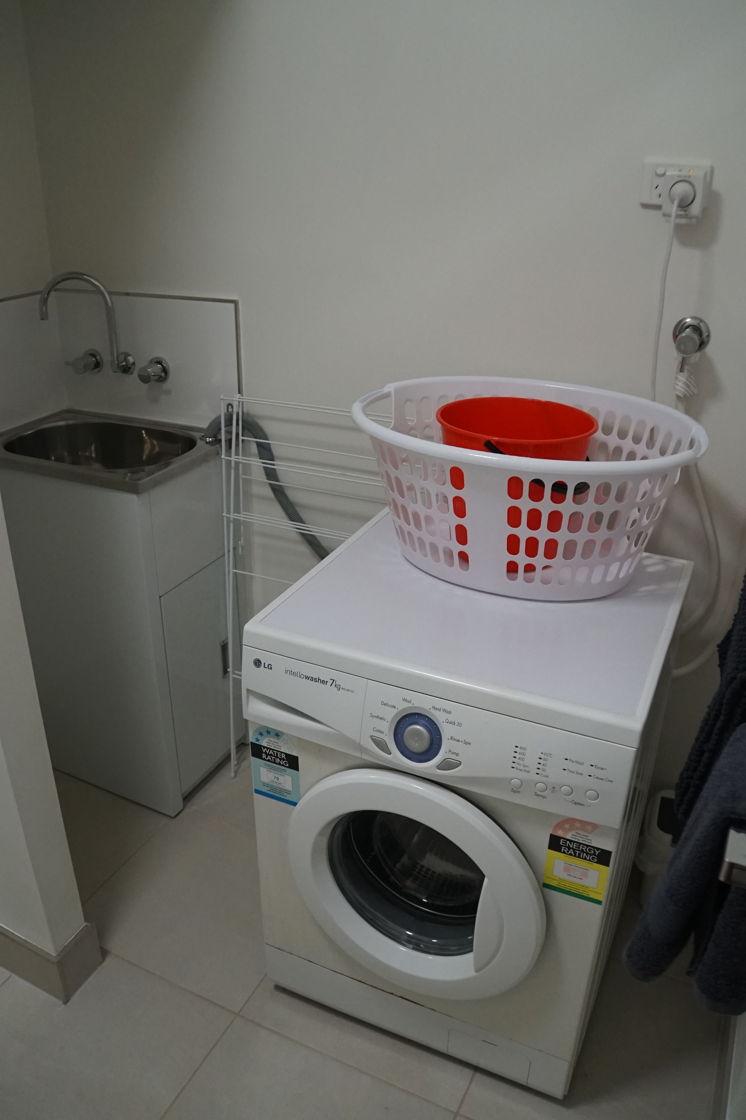 A compact laundry area with a washing machine and a sink.