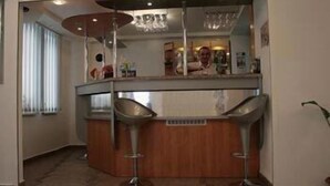 A modern kitchen with a central island, two bar stools, and a chandelier. - Plus Hotel (Malu Mare)