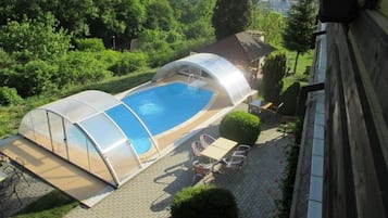 Una piscina al aire libre de temporada, sillones reclinables de piscina