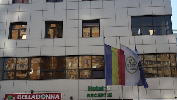 A hotel building with a sign for 'Hotel Belladonna' and a 'Hotel Reception' sign.