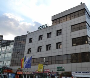 Monikerroksinen hotellirakennus, jossa on moderni julkisivu, suuret ikkunat ja sen päällä näkyvä, huomiota herättävä «HOTEL»-kyltti.