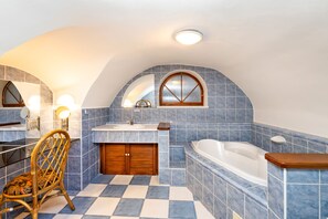 A bathroom with a checkered floor, a wooden chair, a bathtub, and a vanity with a mirror. - Pension Nostalgie - Minihotel (Cesky Krumlov)