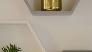 Three gold-colored planters with green plants on a white wall.