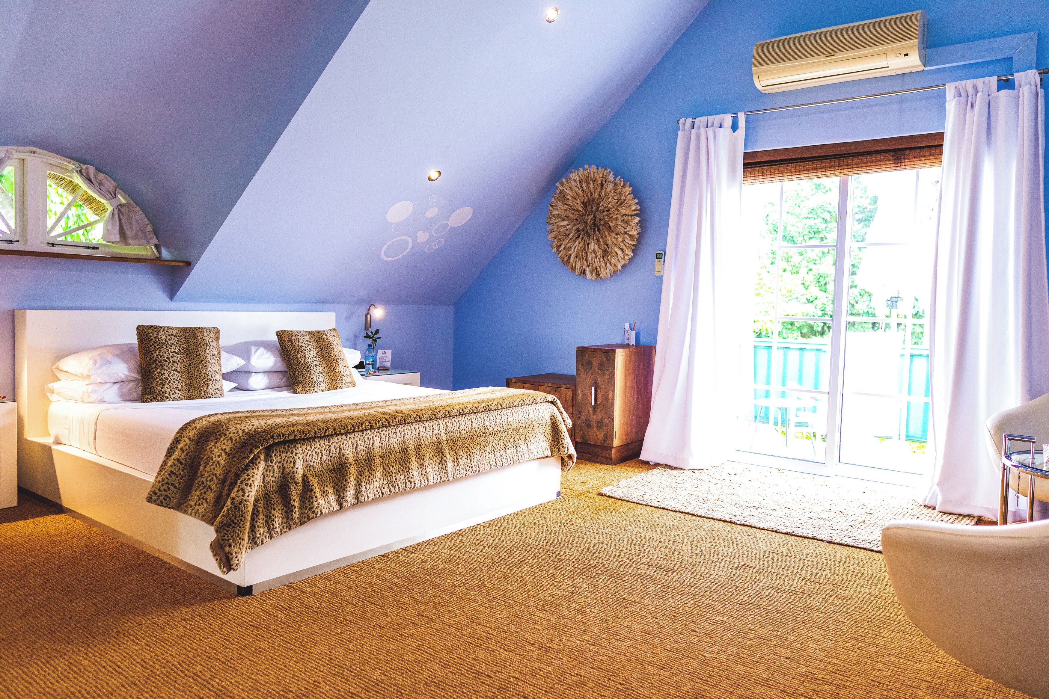 A bedroom with a bed, a nightstand, a dresser, and a chair.