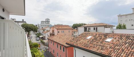 A residential area with terracotta-tiled roofs, a narrow street, and buildings with balconies.