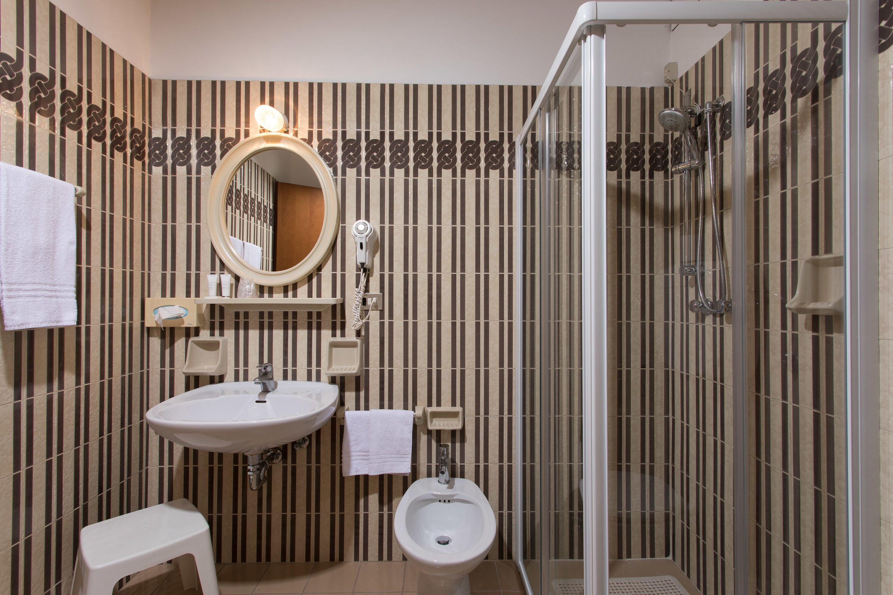 A bathroom with a sink, bidet, and shower.