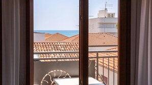 Un balcón con tejado de baldosas y vista al mar.