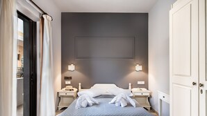 Una habitación de hotel con cama, mesitas de noche y un armario.