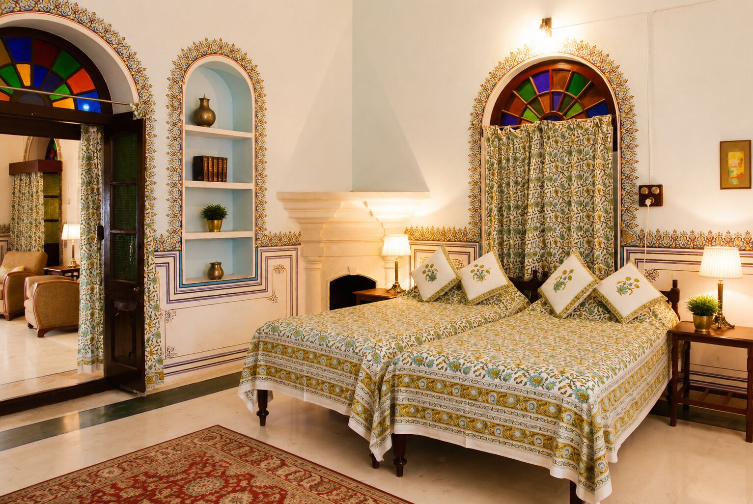 A traditional bedroom with a large bed, a fireplace, and ornate wall decorations.