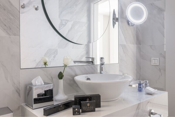 A modern bathroom with a large white sink, a glass vase with a white flower, and a tissue box on the counter. - Suites Center Barcelona (Barcelona)