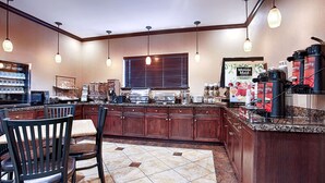 Eine Hotelküche mit Büfett, darunter eine Kaffeestation und verschiedene Speisen.