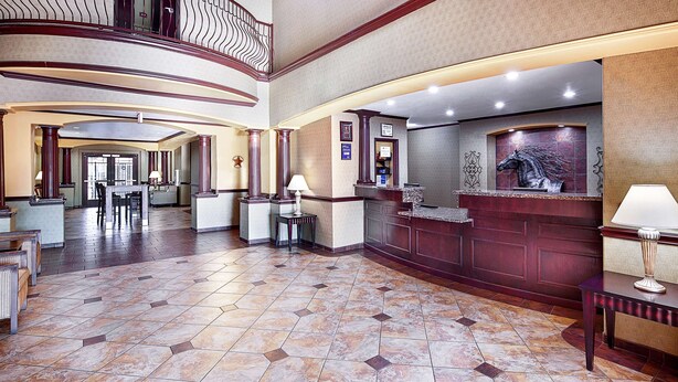 Eine großzügige Lobby mit hoher Decke, einer Rezeption und einer Sitzecke.