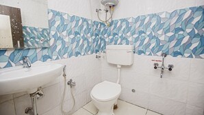Un baño con inodoro blanco, lavamanos y ducha.