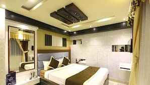 Habitación de hotel moderna con una cama grande, una mesita de noche, un espejo y un baño con lavabo e inodoro.