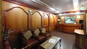 Un interior tradicional con paneles de madera, mostrador de recepción, zona de estar y un reloj.