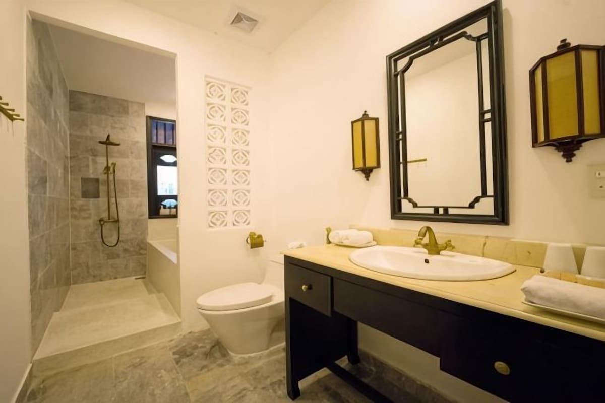 Un baño con ducha, inodoro, lavabo y tocador.