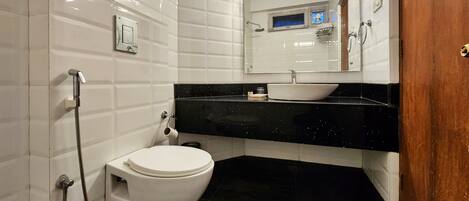 Une salle de bain avec des toilettes, un lavabo et une douche.